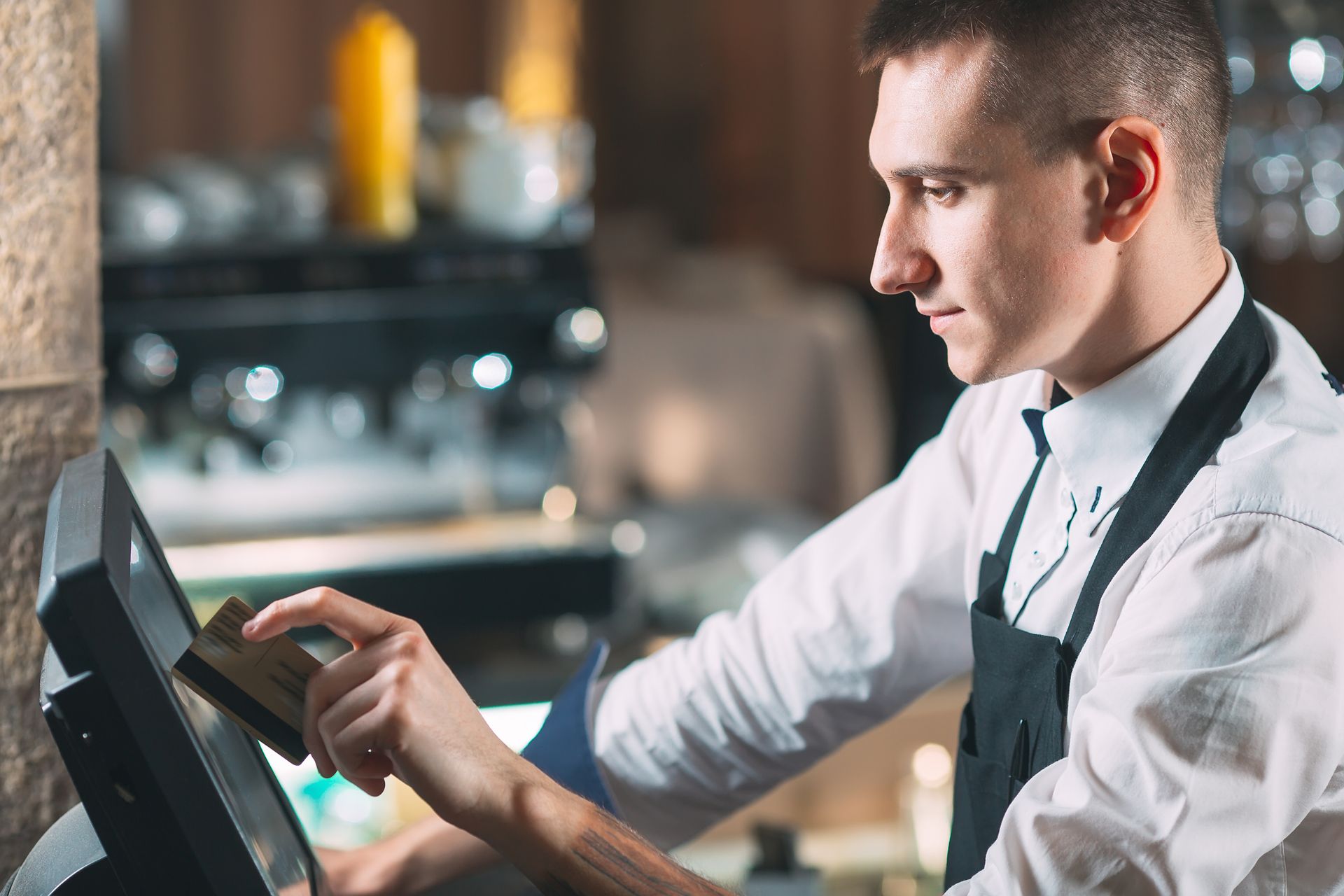 User-friendly interface for quick and accurate order processing Restaurant staff using touchscreen POS device during service